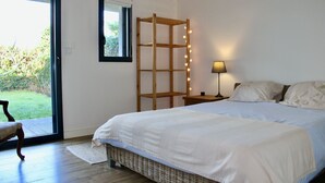 A bedroom with a bed, a nightstand, a lamp, a wooden ladder, and a view of the outdoors. - "Entre nous"-Quiberon center-10p-Parking-Wifi (Quiberon)