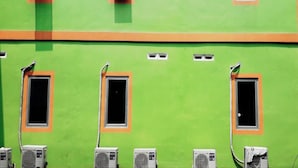 Une façade d’immeuble avec de nombreuses fenêtres et des unités de climatisation.