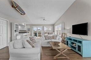 A spacious living room with a white sofa, a wooden coffee table, and a blue cabinet. - Experience oceanfront bliss at Life of Sea-Renity in Holden Beach, NC! (Holden Beach)