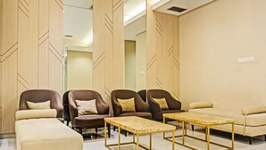 Eine moderne Lounge-Ecke mit Sofas, Sesseln und einem Couchtisch.