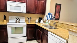 A kitchen with a stove, microwave, oven, and dishwasher.