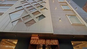 The exterior of the Hotel Golden Glory with a modern architectural design, featuring a prominent geometric facade and a lit signboard. - Hotel Golden Glory (New Delhi)