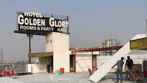 A rooftop terrace of Hotel Golden Glory with a signboard, tiled flooring, and some construction materials. - Hotel Golden Glory (New Delhi)