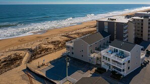 A beachfront hotel with multiple floors, a pool, and a view of the ocean. - Beautiful townhouse with outdoor pool  Free WiFi, linens included and right at the beach. (Ocean City)
