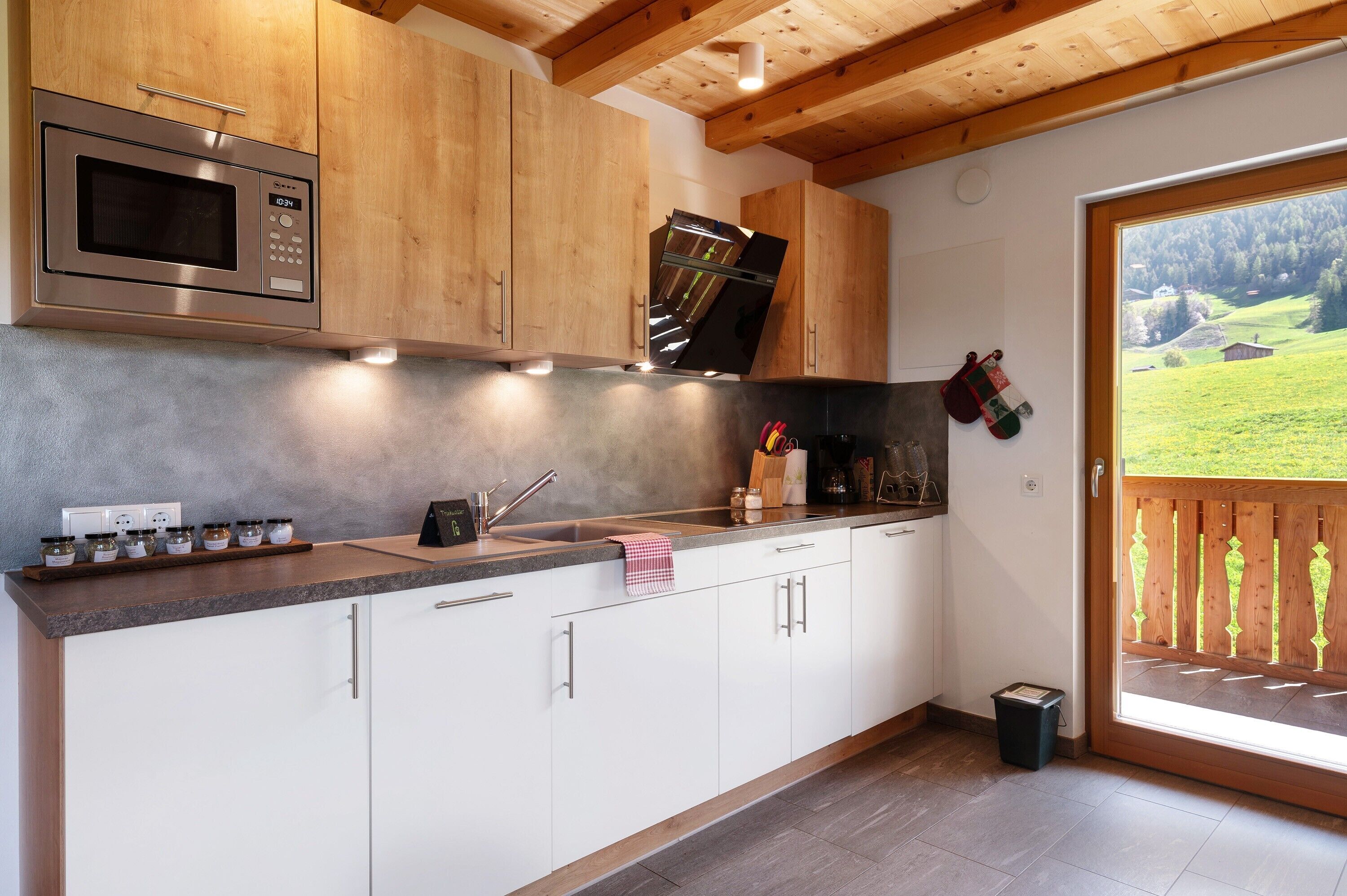 A modern kitchen with wooden cabinets, a stainless steel microwave, and a built-in oven.