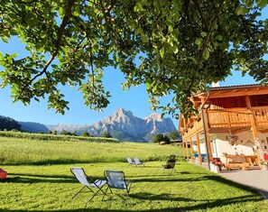 A wooden chalet with a mountain view, outdoor seating, and a garden. - Apartment 'Schererhof Abendrot' with Mountain View, Private Terrace and Wi-Fi (Castelrotto)