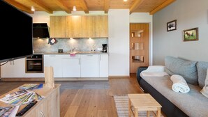 Eine moderne Küche mit Holzausstattung, einem Backofen und einem Essbereich mit Tisch und Stühlen.