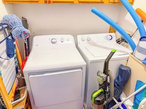 A laundry area with two washing machines and a hose. - Tilghman Beach and Racquet Club 209 (North Myrtle Beach)
