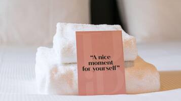 Una cama bien hecha con sábanas blancas y una etiqueta que dice 'Un momento agradable para ti'.