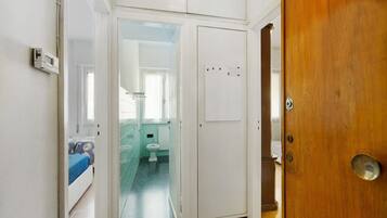 Una habitación con cama, baño con inodoro y lavamanos, y una puerta de madera.