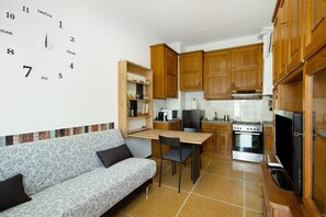 A compact kitchen with wooden cabinets, a built-in microwave, and a stove.