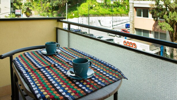 Ein Balkon mit Tisch, Tasse und Löffel.