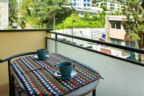 Un balcon avec une table, une tasse et une cuillère.