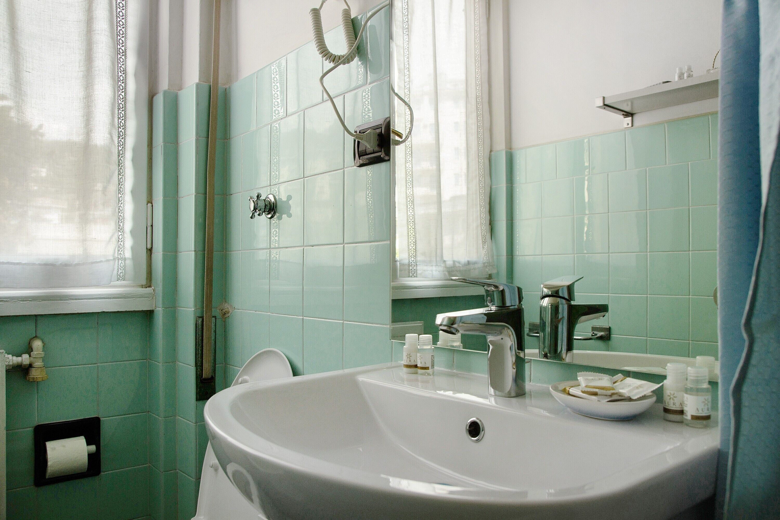 Ein Badezimmer mit Waschbecken, Spiegel und Handtuchhalter.