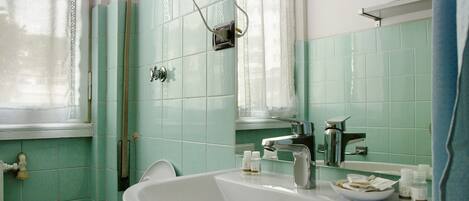 A bathroom with a sink, mirror, and a towel rack.