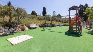 A playground with a climbing structure, a seesaw, and a shuffleboard table. - Holiday Home 'Fattoria Spezia - Limone' with Shared Pool, Shared Garden and Wi-Fi (Buseto Palizzolo)