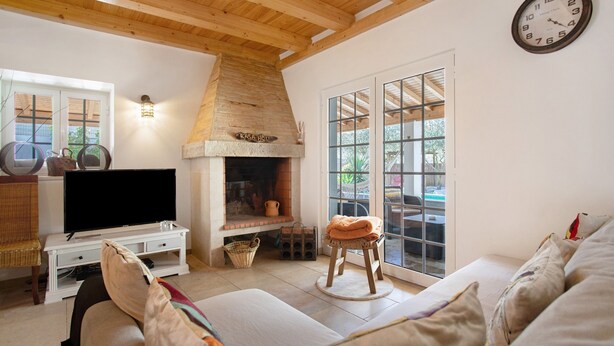 A living room with a fireplace, television, and a sofa. - Holiday Home 'Holi' with Private Pool, Wi-Fi and Air Conditioning (Valada)