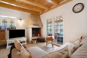 A living room with a fireplace, television, and a sofa. - Holiday Home 'Holi' with Private Pool, Wi-Fi and Air Conditioning (Valada)