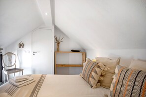 A bedroom with a bed, pillows, a chair, a wooden shelf, and a door. - Holiday Home 'River Sun' with Private Pool, Wi-Fi and Air Conditioning (Valada)
