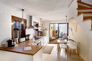 A modern kitchen with a wooden countertop, a built-in oven, and a dining area with white chairs. - Holiday Home 'River Sun' with Private Pool, Wi-Fi and Air Conditioning (Valada)