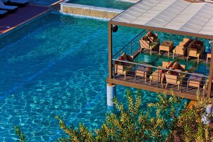 Una piscina cristalina con sillas de descanso y un área de estar techada.