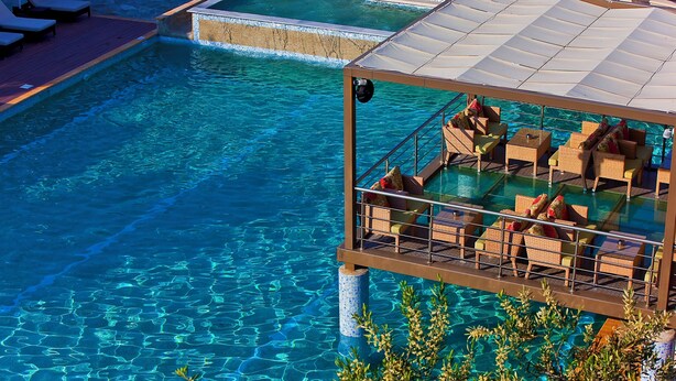 A clear pool with lounge chairs and a covered seating area. - Flegra Palace Hotel & Spa (Kassandra)