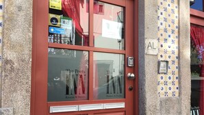 A red door with glass panels, labeled "The Poets INN Rooms & Books." - The Poets Inn (Porto)