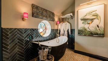 A modern bathroom with a freestanding bathtub, a large mirror, and a wall-mounted towel rack.
