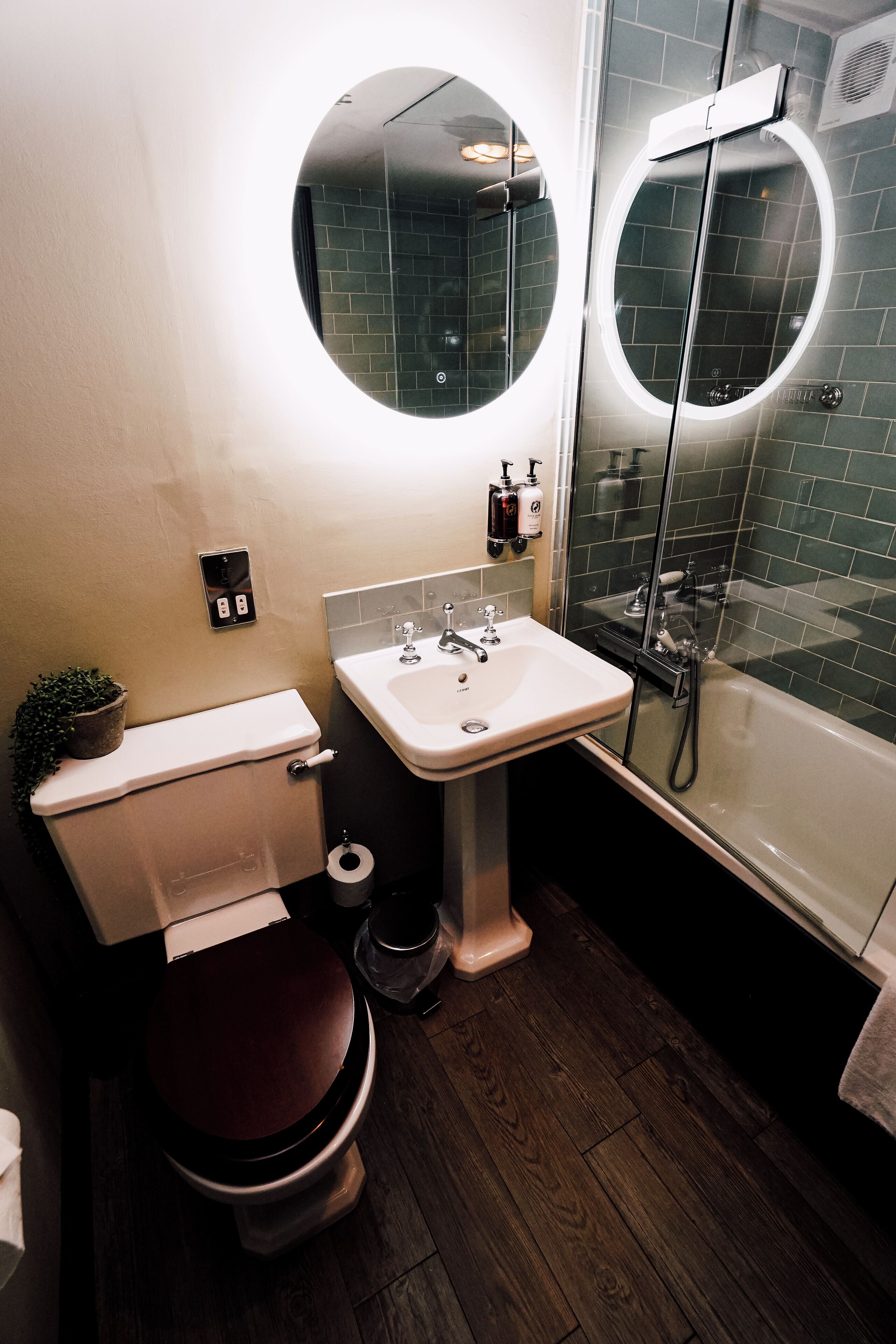 Un baño moderno con inodoro, lavamanos y ducha.