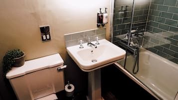 Un baño moderno con inodoro, lavamanos y ducha.