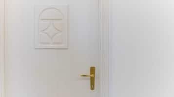 Une porte blanche avec une poignée de porte en laiton et un panneau décoratif.