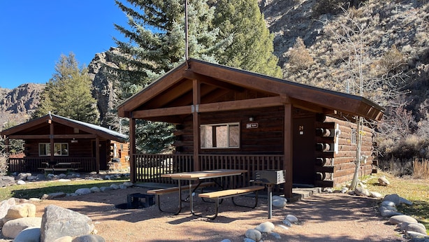 A rustic cabin with a picnic table and rocks in front. - One Bedroom Cabin with Ample Parking and Space from Neighboring Cabins (Almont)