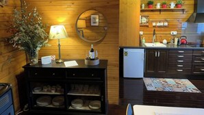 Un intérieur chaleureux en bois, comprenant un coin repas, une petite cuisine et un miroir décoratif.