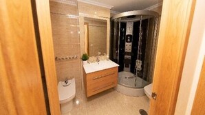 Un baño con lavabo, espejo y ducha.