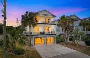 A two-story house with a balcony, a garage, and a covered entryway. - Walk to Beach Second Row Home w/ Private Pool & Hot Tub (Surfside Beach)