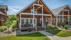 A modern wooden house with a large porch, multiple windows, and a well-maintained lawn. - Dover Bay 'Barefoot Bungalow' | Marina + Trails (Dover)