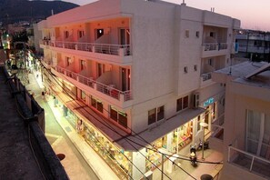 A multi-story hotel with balconies, a ground floor with shops, and a view of the street. - Nancy (Hersonissos)