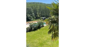 A pool area with a view of a forested hill. - Gîte le grand chacel (Sourcieux-les-Mines)