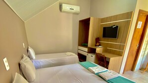 A bedroom with two beds, a TV, a wardrobe, and a desk. - Pousada Beira da Mata (Mateiros)
