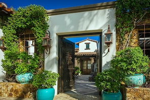 Enter a traditional building with a welcoming entrance, framed by a stone wall and a black door.