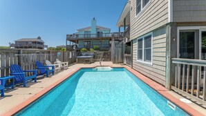A rectangular swimming pool with blue chairs and a wooden deck. - The BARNacle - Corolla, Ocean Sands, 5 Min. Walk to Beach, Pool, Hot Tub, Pets OK, Flex Stays (Corolla)
