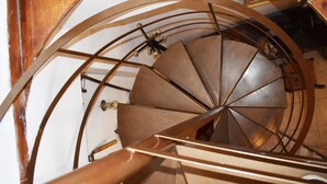 A spiral staircase with a metal handrail and a wooden wall. - Ethia 2floor Mountain View Cottage Garden Wifi ac (Archanes-Asterousia)