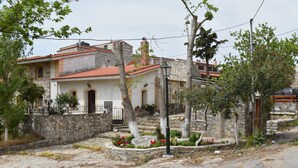 A traditional stone building with a tiled roof, a stone wall, and a small garden with flowers. - Ethia 2floor Mountain View Cottage Garden Wifi ac (Archanes-Asterousia)