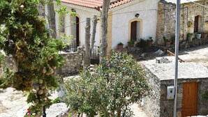 A traditional stone building with a tiled roof, arched windows, and potted plants. - Ethia 2floor Mountain View Cottage Garden Wifi ac (Archanes-Asterousia)
