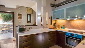 Una cocina moderna con armarios de madera oscura, una encimera blanca y un horno empotrado.