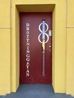 Una puerta roja con el nombre 'DROTTINGATAN' en letras blancas.