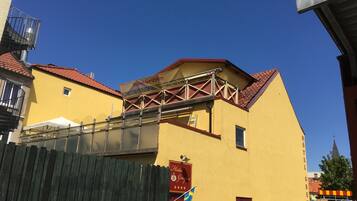 A yellow building with a red roof, a sign reading "Hotel Gruyère," and a flag.