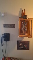 Una pared con un cartel de una motocicleta antigua, un letrero que prohíbe fumar y una escultura de metal decorativa.