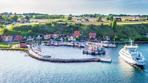 Un pueblo costero con un puerto deportivo, casas y un muelle para transbordadores.