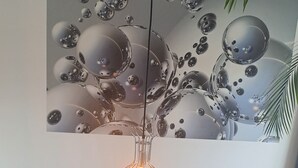 Una sala de estar moderna con un sofá de cuero oscuro, una mesa de centro de madera y una lámpara colgante.